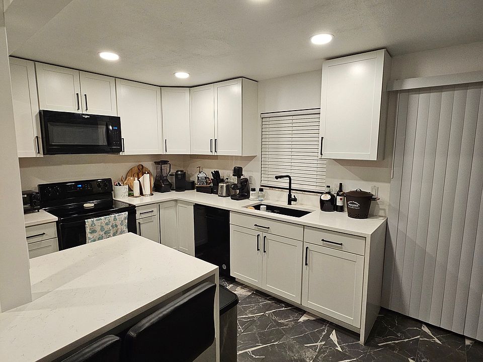 The kitchen features built-in Whirlpool appliances, including a refrigerator, dishwasher, stove, microwave, and garbage disposal. A deep farm-style sink adds both function and charm to the space.