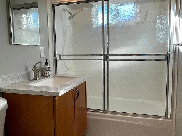 Bathroom with tub/shower combo and natural light from the west facing window.