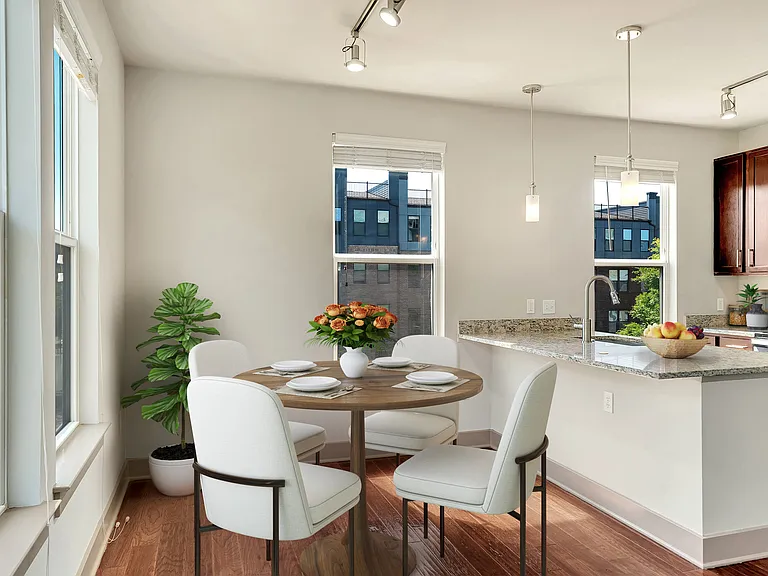 A kitchen with a table and chairs by a window.