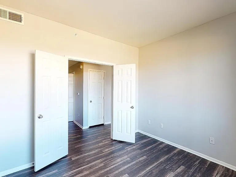 Spacious apartment study with wood-style flooring.