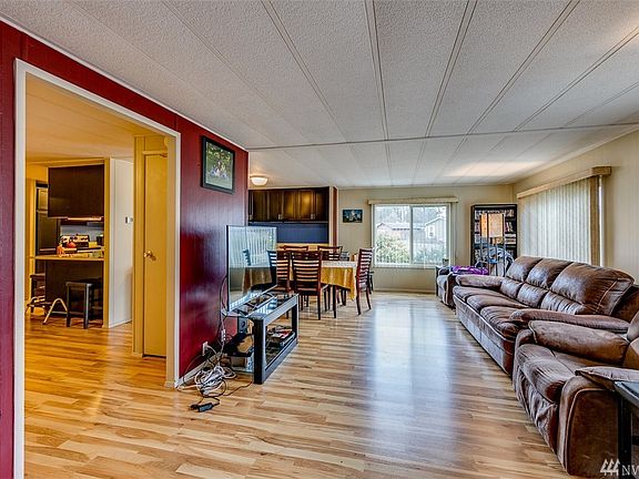 Entering the home, you see the easy-care wood laminate flooring across the living room, dining room and family room (to left through opening).  Lots of windows bring in the light.
