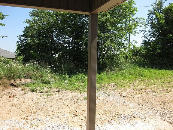 Neat covered back porch looks on to mature trees