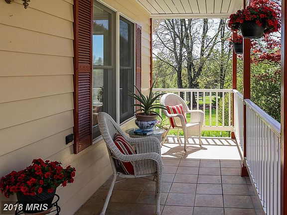 Relax on the front porch with views of tall trees