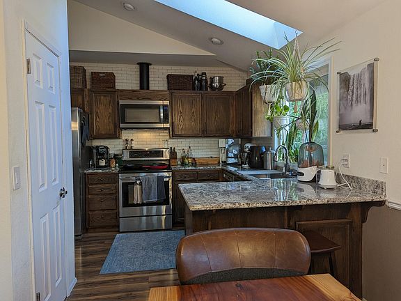 Dining room looking into the kitchen - features a large window and skylight as well as walk-in pantry on the left