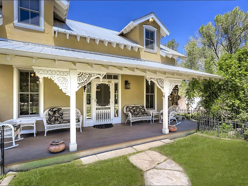 Front of home surrounded by beautiful garden.