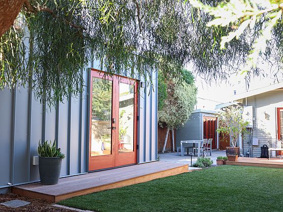 Looking back at the shared backyard and patio, with the Owner's home and shed in the background.