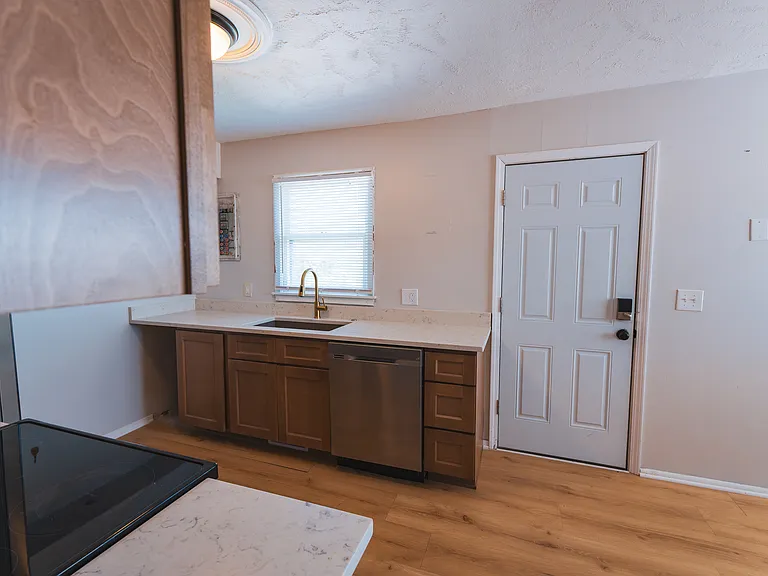 Newly designed kitchen with new cabinets, countertops, sink, hardware, and flooring
