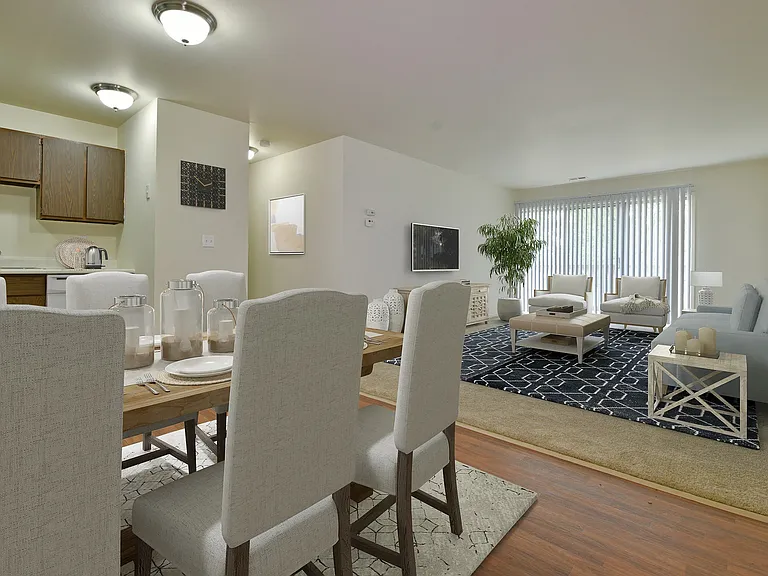 The open living room with a sliding glass door and dining room.