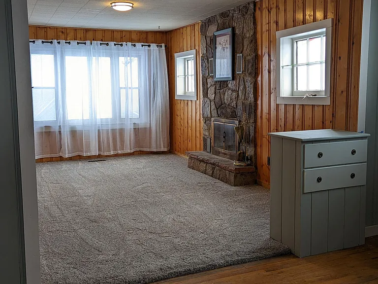 Plush carpeting, wood burning fireplace and large windows make this a wonderful place to gather in any season