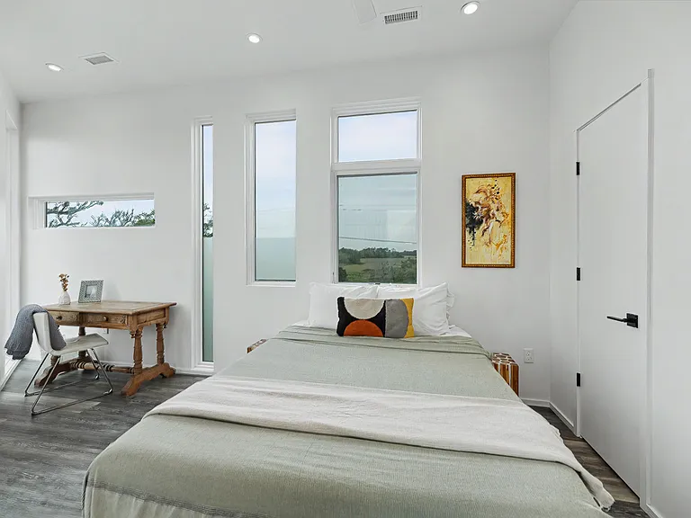 Main level bedroom with queen bed and workspace with desk/chair