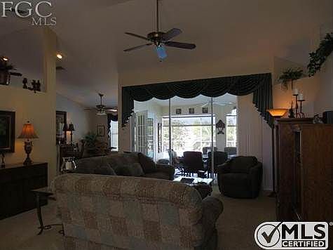 Great room with sliding doors to lanai and pool area. Dinette in background, high ceilings through out.