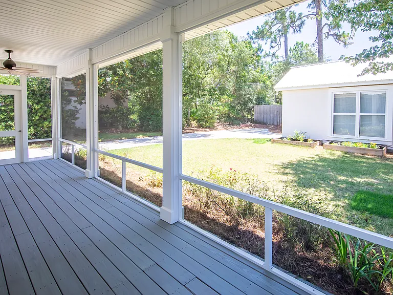 The screened in porch overlooks the backyard and detached garage.