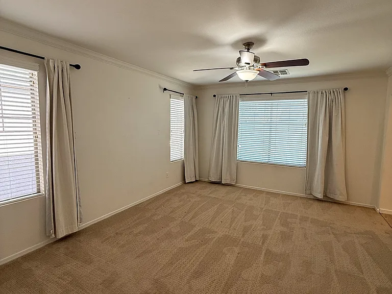 Spacious primary retreat featuring custom designer wall treatments and abundant natural light.