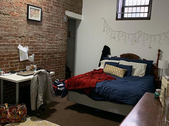 Large bedroom with brick wall and 2 closets