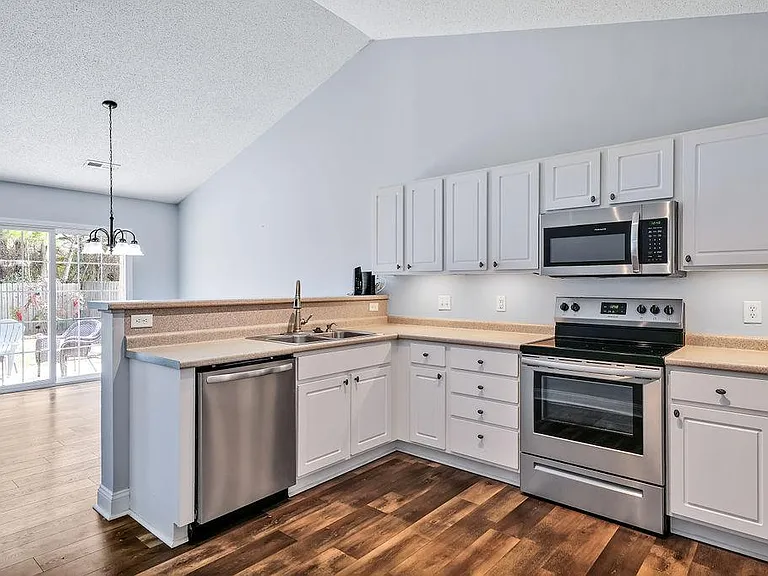 Kitchen with open view of the dining room and sliding door to the back yard