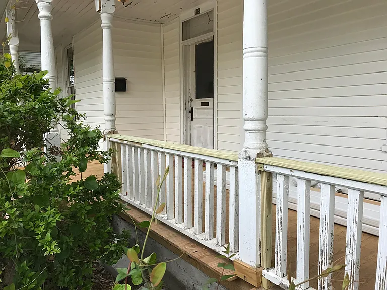 Porch rebuilt, new boards, now painted "battleship grey" with a brick red door.