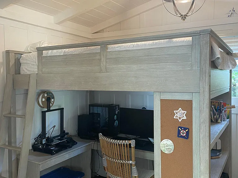 Small bedroom/study off of living room with grey barn yard doors that close for privacy