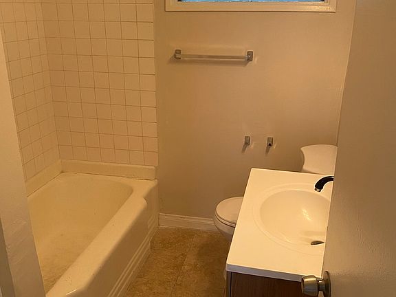 Remodeled bathroom with new shower/tub combo, sink, fixtures, and flooring
