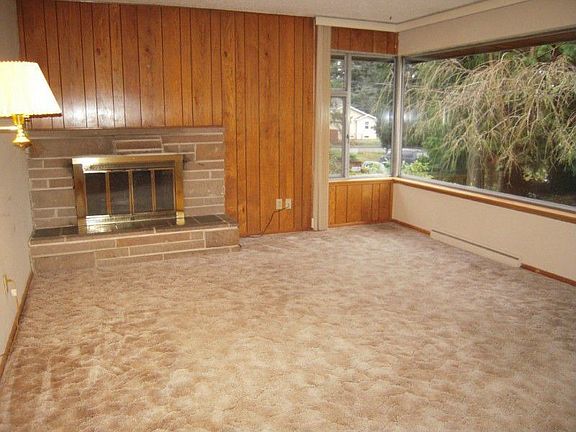 Bright living room with large corner windows and fireplace