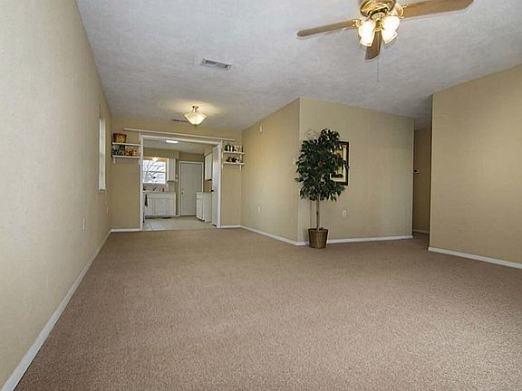  The living room opens to the dining area (with its own light fixture) plus the kitchen. Note the great neutral wall color.