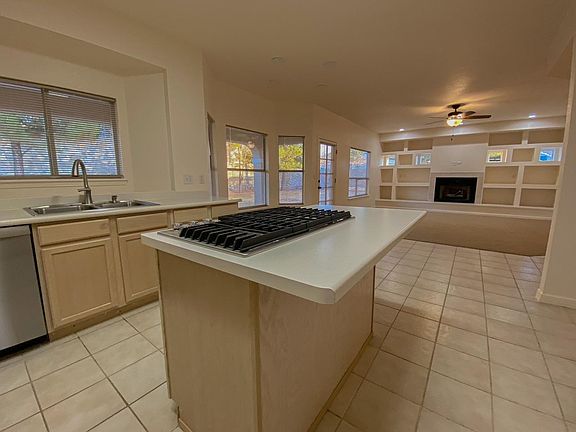 A closer view of the new stainless-steel gas stovetop, partial view of the new Bosch dishwasher, and the family room.