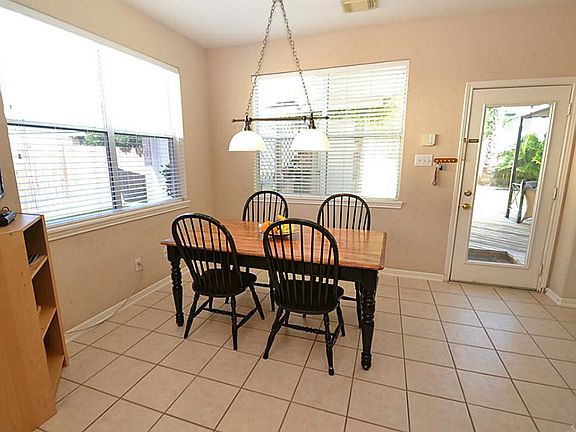 Breakfast room highlighted by tile floors, open to the kitchen and a door opening to the large decked patio area.