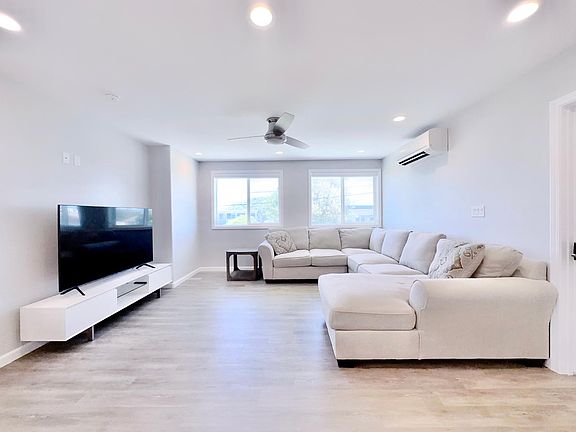 65in brand new tv in the living room with large sectional.