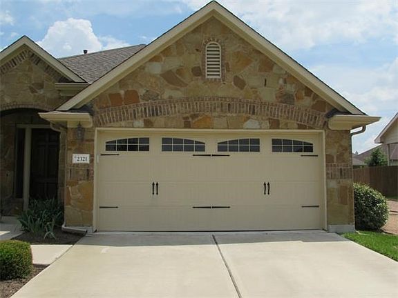 Warm and welcoming with custom garage door