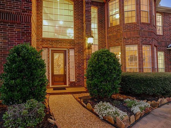 Welcoming entryway with beautiful landscaping.