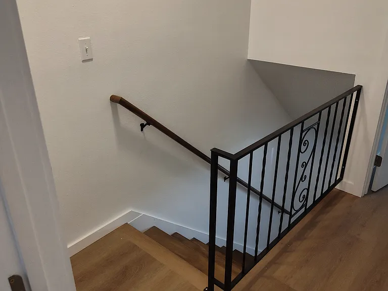 Standing at the top of the stairs by the back bedroom.
