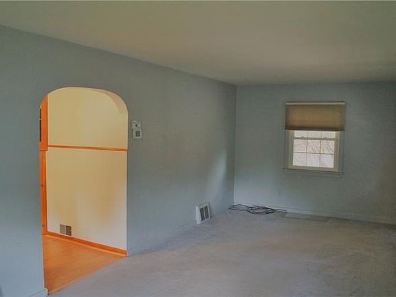 Another view of the den showcasing the charm of the archway and neutral paint.
