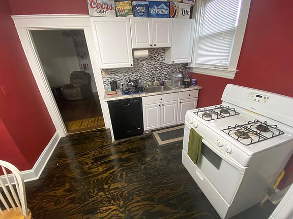 View from kitchen into living room. Real wood grain floor.
