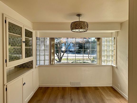Dining area with antique built-in hutch and large bay window, lets in tons of natural light.
