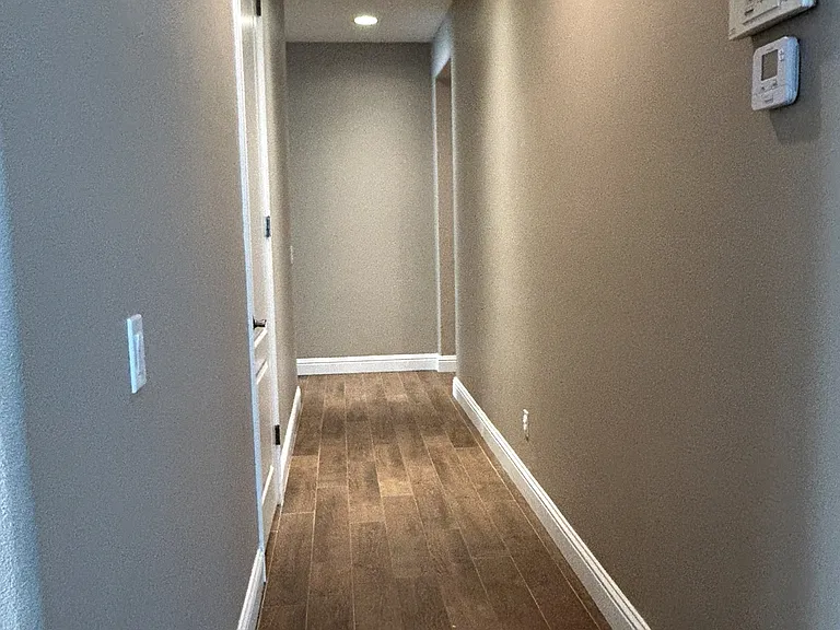 hallway to Master bedroom, two other rooms, laundry room and hallway bathroom with double sink
