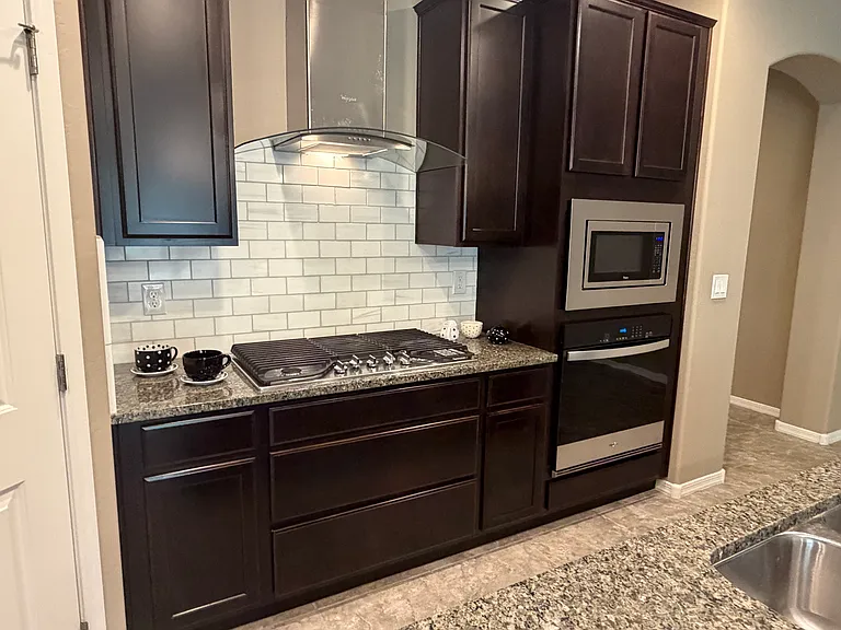 Kitchen cooking center with gas range, microwave and electric oven. Plenty of cabinet space for your kitchenware. Granite countertops in kitchen and bathrooms.