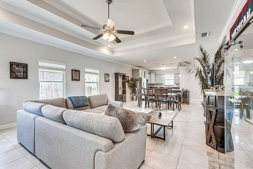 The living room with a smart TV that includes a soundbar and cozy, modern couch