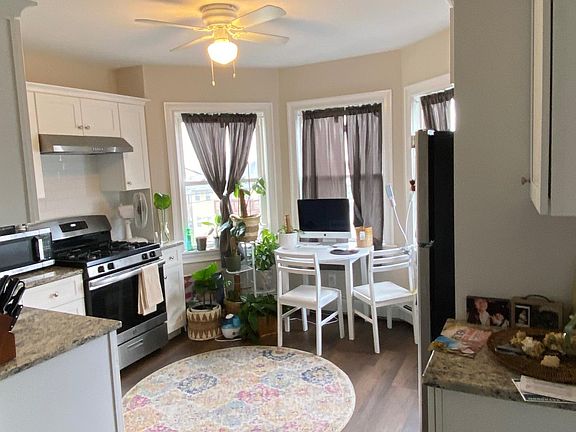 Kitchen view of table in front of three corner windows