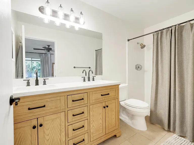Well-appointed primary bathroom with dual sinks, granite countertop vanity, and a walk-in shower for added comfort.