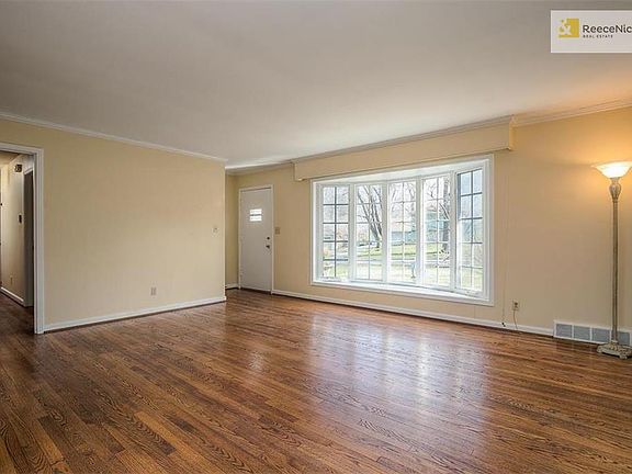 The spacious Living Room boasts gleaming hardwood floors, smooth ceilings and a large bay window.