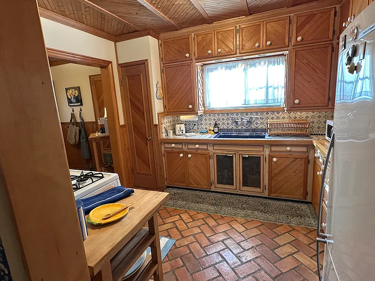 Kitchen with charming brick floor and blue porcelain sink