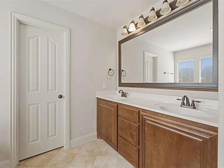 Bathroom featuring double vanity and light tile patterned floors