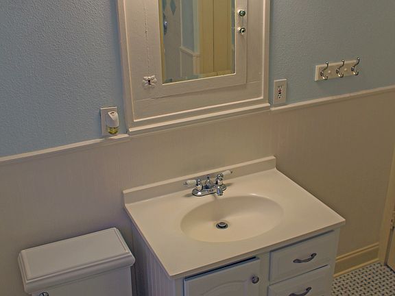 Clean, quaint bathroom has original basket weave tile and me