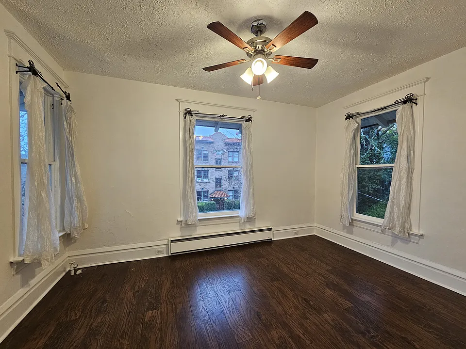 A bright, freshly painted dining area filled with natural daylight, versatile enough to be used as a living room or office.