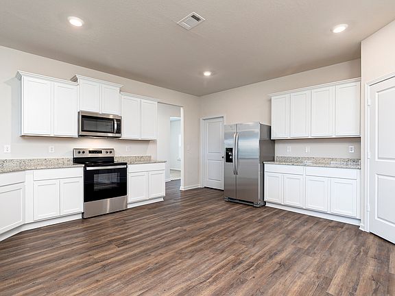 Stunning kitchen with white cabinets, stainless appliances, and granite countertops.