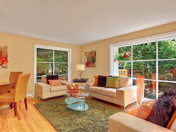 Living room with dining area and wonderful, light filled windows to the fenced courtyard.