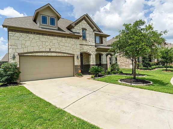 Nice long, double wide driveway and 2 car attached garage allows for plenty of parking. This angle allows you to see the covered porch area, just beneath the 3 archways. The 2 oaks in the front yard will provide plenty of shade as they continue to gr