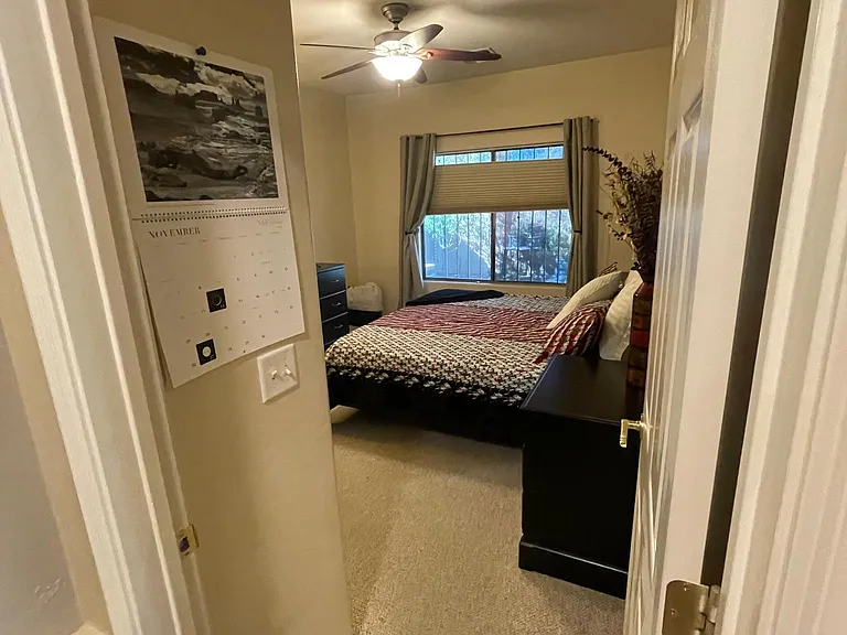 View from hallway into master bedroom. Window has blackout blinds that open from the top or bottom.