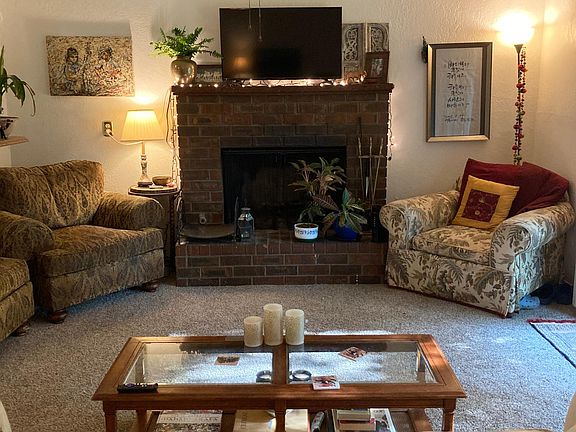 Living room with wood burning fireplace and vaulted ceilings