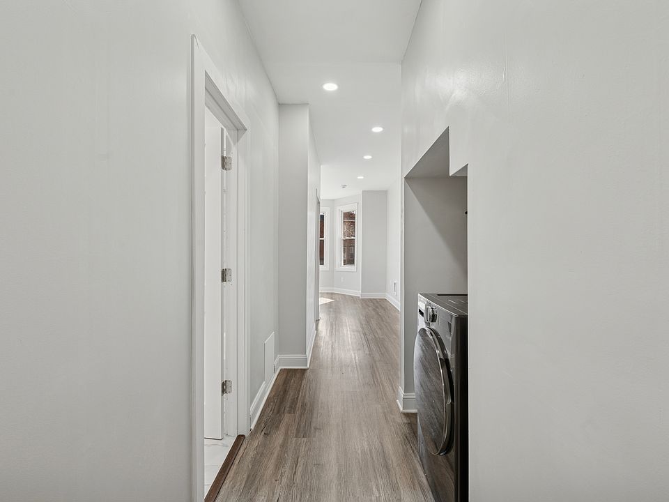 Spacious hallway, with lots of options for use, and a tucked-away laundry area with shelving
