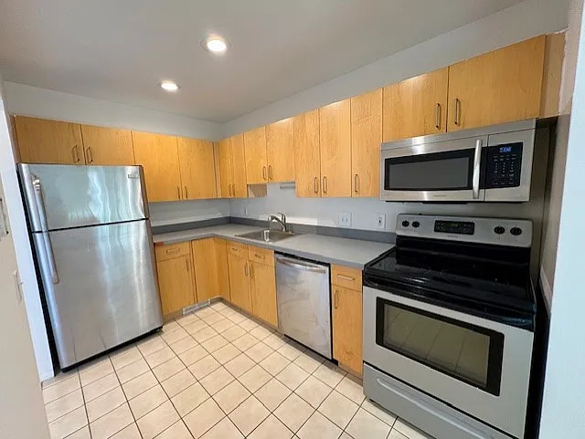 contemporary kitchen with stainless appliances including built in microwave
